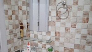 A bathroom with a white sink, a mirror, and a towel ring. - Ali Jasem Group (Doha)