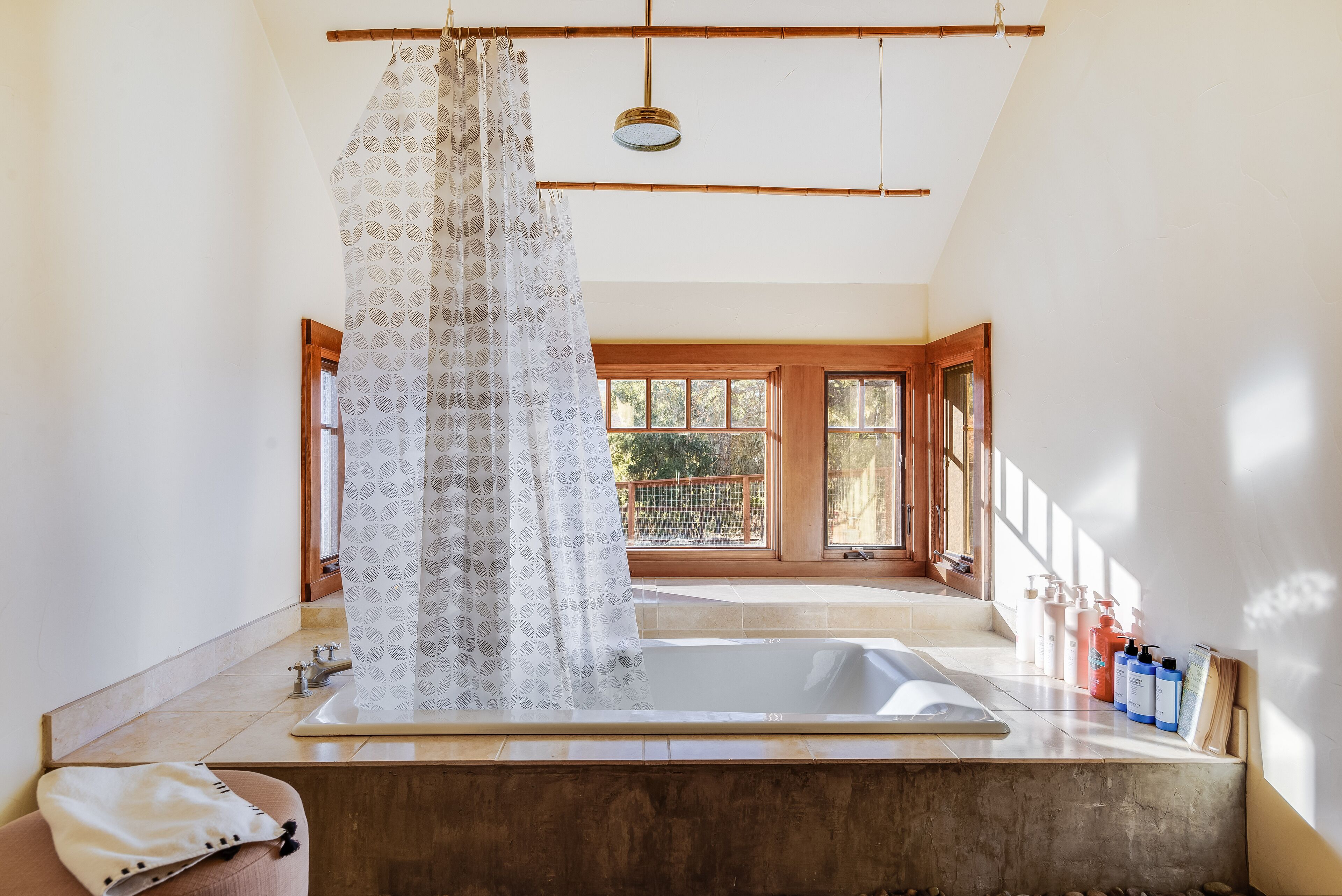Une salle de bain équipée d’une baignoire, d’un rideau de douche et d’articles de toilette.