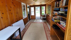 A wooden interior with a white table, a bookshelf, and a door leading outside. - Trailview: Walk to Stadium! Free Fubo for World Cup, Plenty of Parking!  Dogs OK (Raytown)