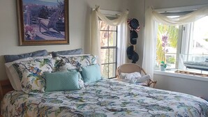 A bedroom with a large bed, a ceiling fan, a window with curtains, and a framed picture on the wall. - Key Largo heavenly retreat (Key Largo)