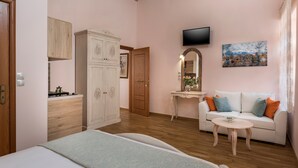 A bedroom with a bed, a dresser, a vanity, a television, and a sofa. - Luxury king size studio with terrace at the heart of Chania old town (Chania)