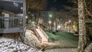 A snow-covered outdoor area with a staircase leading to a building, surrounded by trees and illuminated by streetlights. - Slopeside Beech Mtn - Ski-In/Ski-Out - Beat the Heat - Biking + Mountain Views (Beech Mountain)