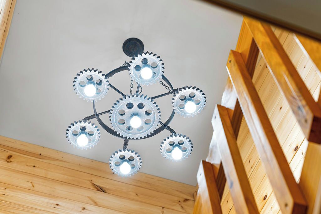 A ceiling with a unique gear light fixture.