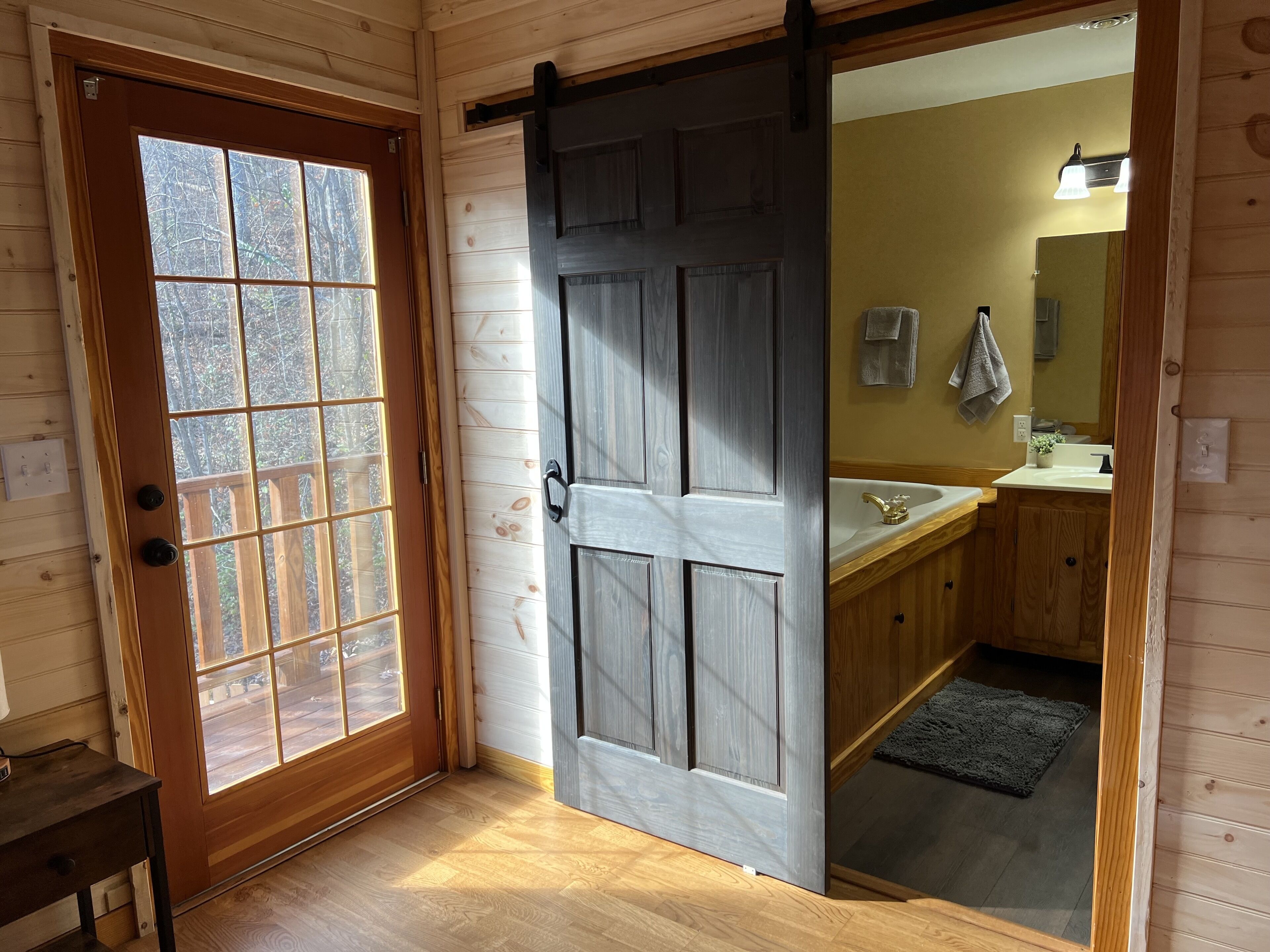 A wooden interior with a sliding door leading to a bathroom.