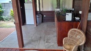 A covered outdoor kitchen area with a refrigerator, a trash bin, and a bar area with a blender and a scale. - Bungalow Temanea Pirae Tahiti (Papeete)