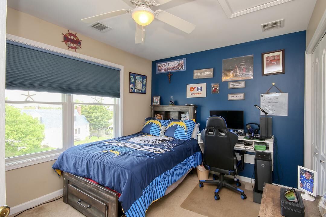 Un dormitorio con cama, escritorio, silla y ventana con persianas.