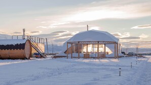 A snow-covered outdoor area with a wooden structure and a covered seating area.