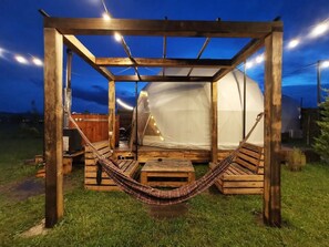 A wooden structure with a hammock, a tent, and a table. - Jewelberry Glamping (Mtskheta)