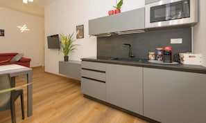 A modern kitchen with grey cabinetry, a microwave, and a coffee maker. - Royal Turin (Torino)