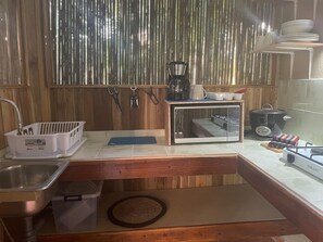 A kitchen with a microwave, coffee maker, and gas stove.