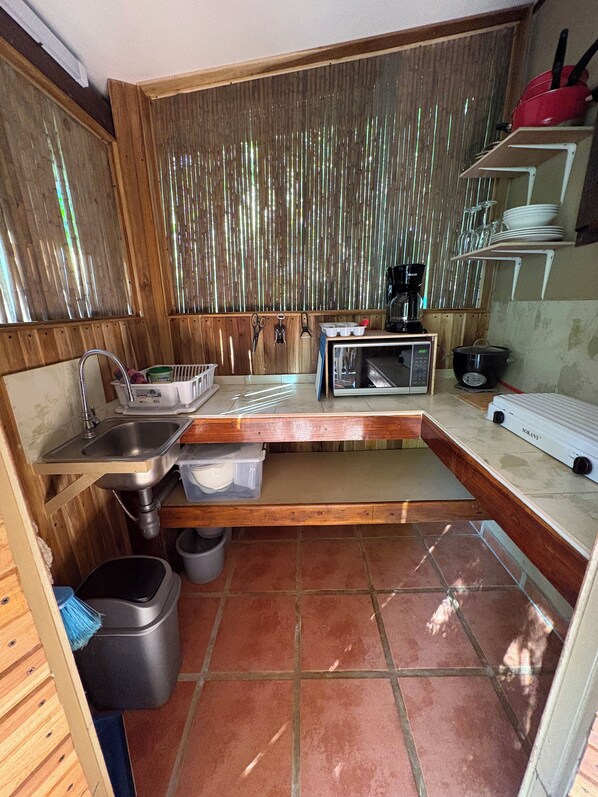 A compact kitchen with a sink, a microwave, and a coffee maker.