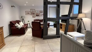Ein modernes Wohnzimmer mit Kamin, Ledersofas und einem Essbereich.