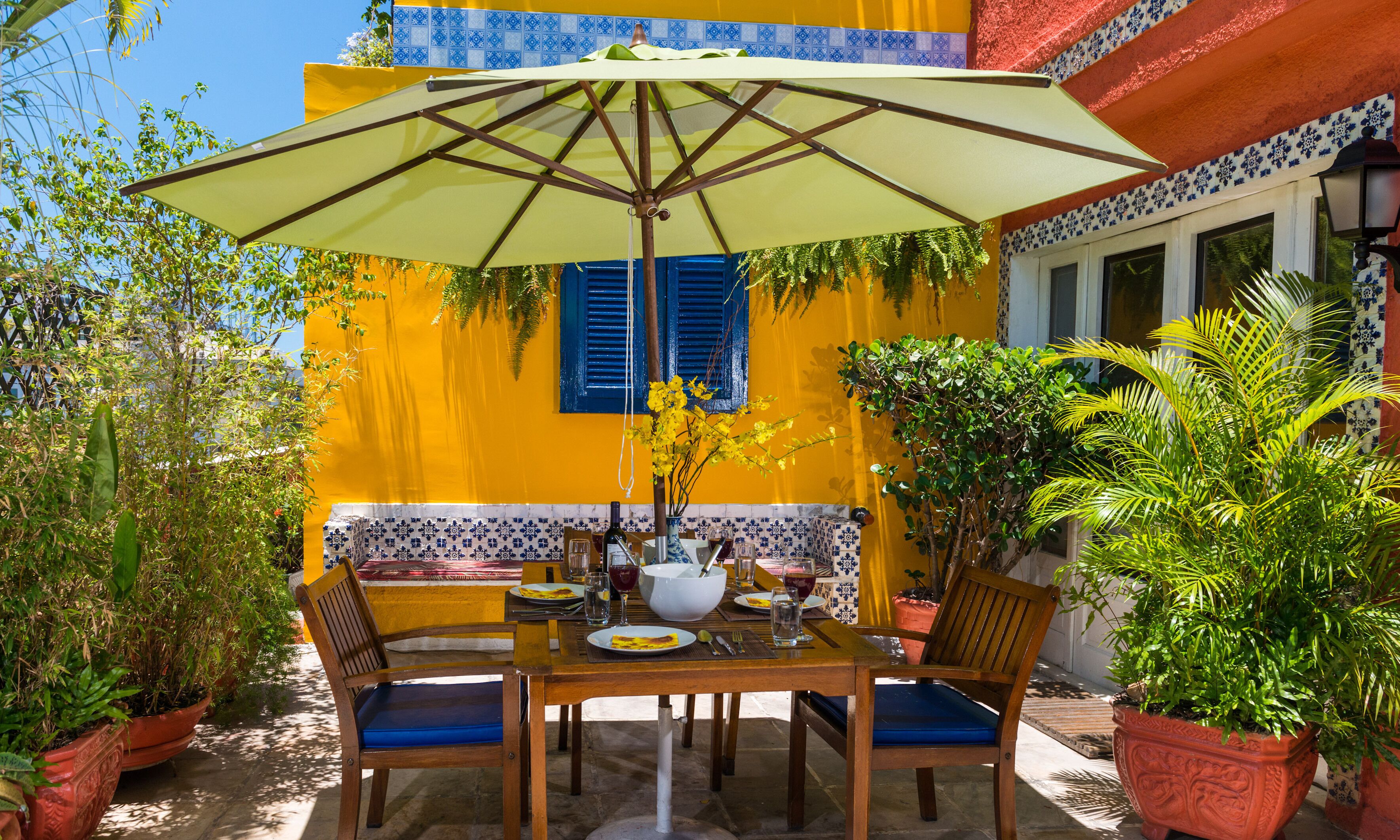 An outdoor dining area with a table, chairs, and a large umbrella.