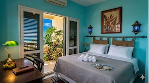 A bedroom with a bed, a desk, a chair, a window with blinds, a door, and a view of greenery outside. - The Coral Penthouse - 3 Bedrooms (Rio de Janeiro)
