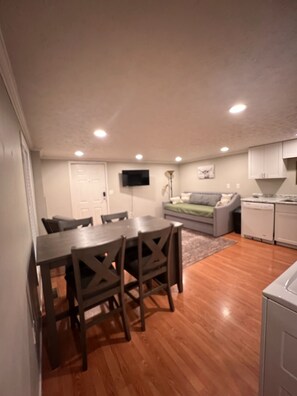 A compact living space with a dining table, chairs, a sofa, a TV, and kitchen appliances. - Hideaway close to Cherokee Lake (Bean Station)