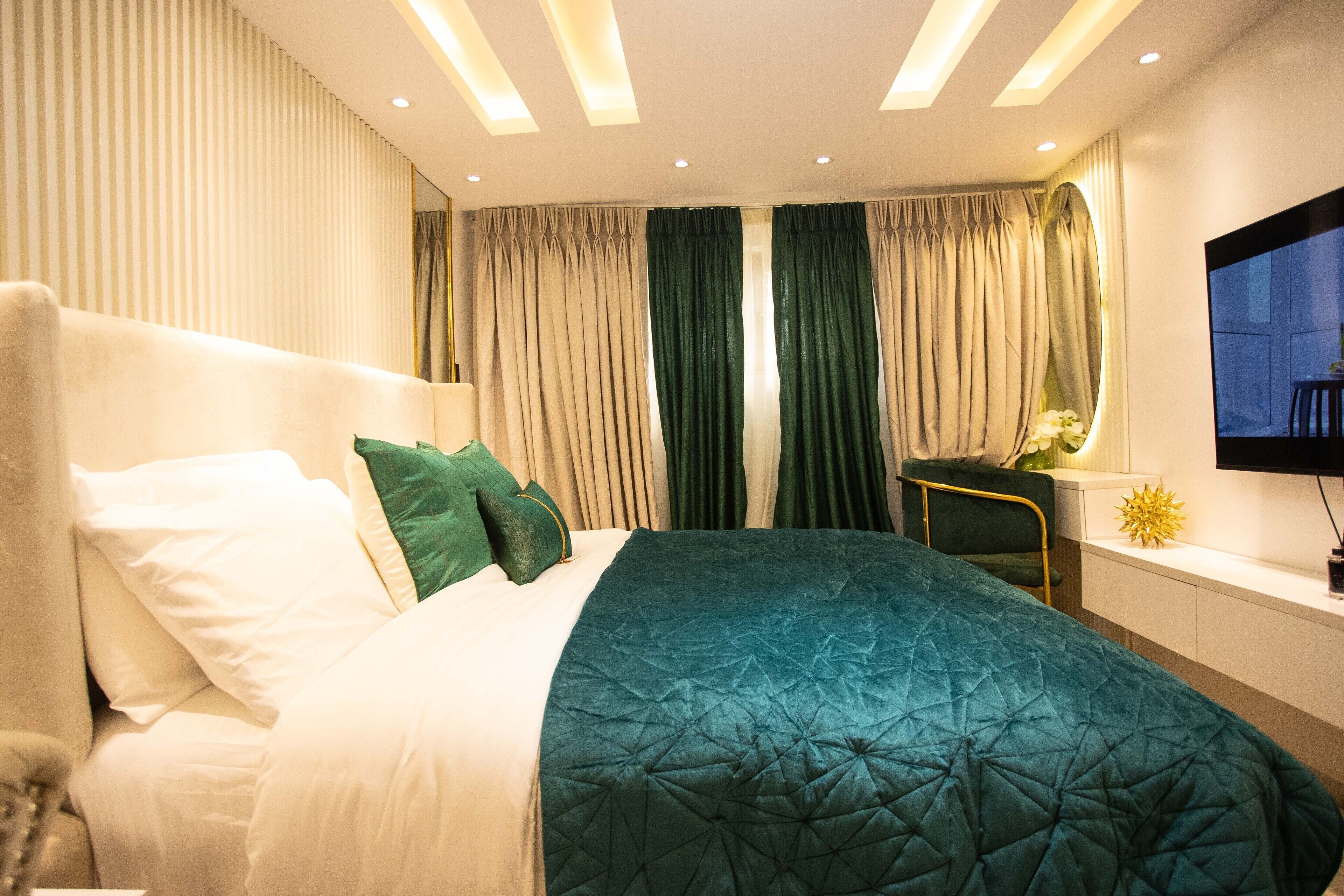 Ein modernes Schlafzimmer mit einem großen Bett, einem Schreibtisch und einem Fernseher.