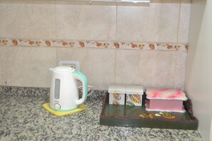 A kitchen with a white kettle on a yellow coaster, a pink tray, and a box with a leaf pattern. - House ideal for up to 7 pax with private garage (Mendoza)