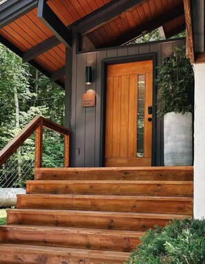 Una escalera de madera que conduce a una puerta con la leyenda 'leeward chalet'.