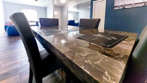 A dining area with a marble table, black chairs, and a ceiling fan. - Tropical Paradise - Private Heated Pool, Screened Lanai, No Cleaning Fee (Lakeland)