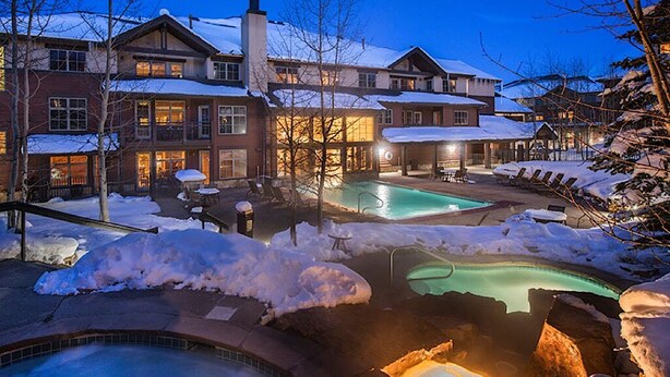 Un grand complexe hôtelier doté de plusieurs piscines, d’un jacuzzi et offrant un paysage enneigé.