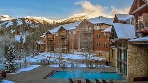 Un complexe hôtelier doté d’une piscine, de plusieurs bâtiments et offrant une vue sur une montagne enneigée.