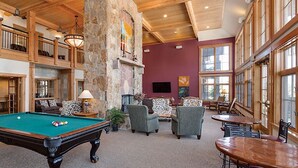 Un espace intérieur vaste et lumineux, doté d’une table de billard, de sièges confortables et de grandes fenêtres.