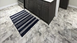 A modern kitchen with dark cabinets, a white countertop, and a stainless steel sink. - Finest BR Free Parking/Wifi TV Shared Suite (Milton)
