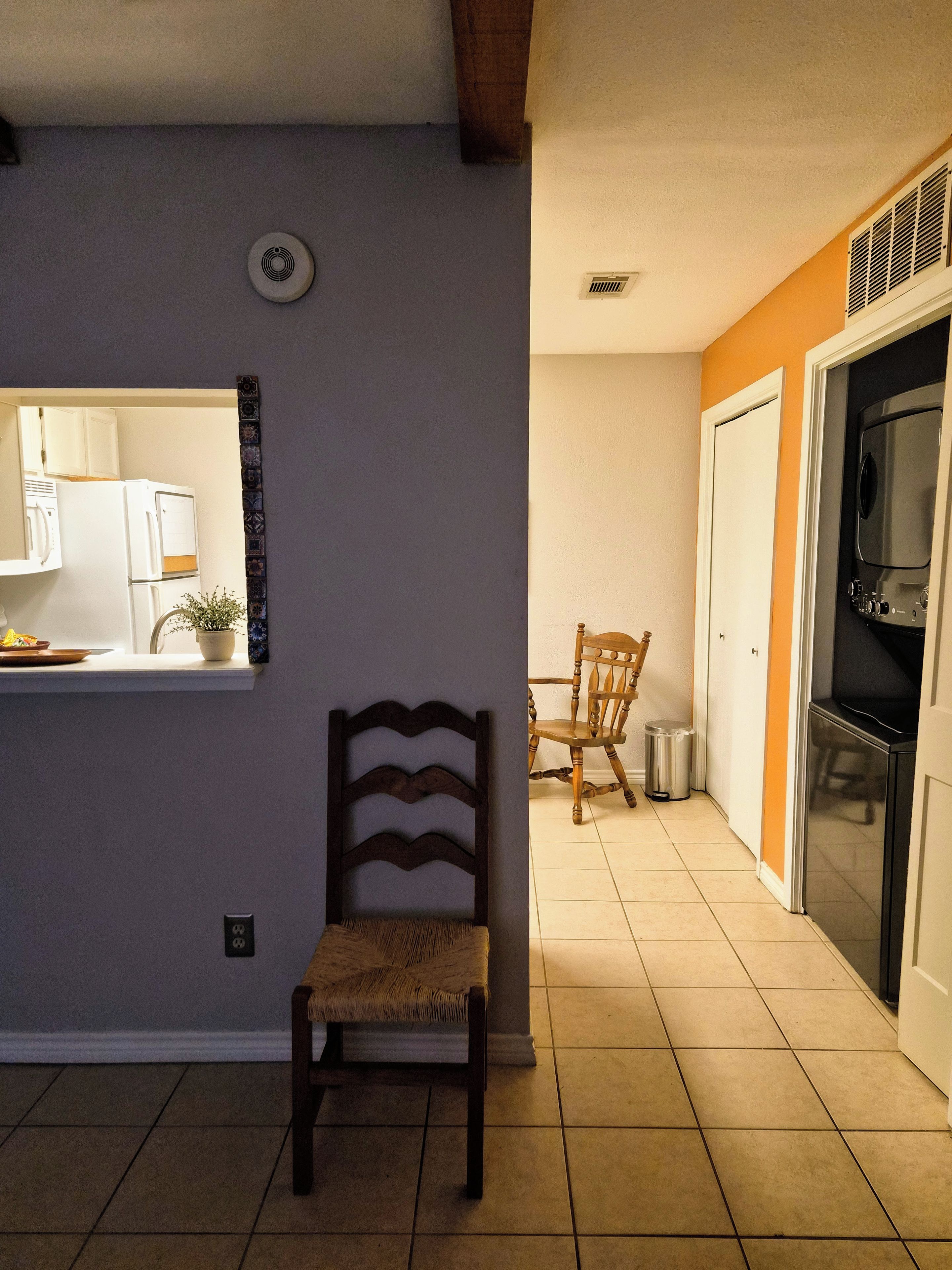 A kitchen with a refrigerator, stove, and a window overlooking the dining area.