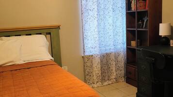 A room with a bed, a bookshelf, and a desk.