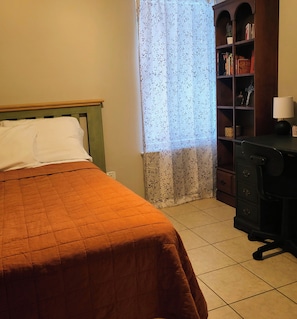 Ein Zimmer mit einem Bett, einem Bücherregal und einem Schreibtisch.