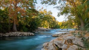 A river flowing through a rocky landscape with trees on either side.