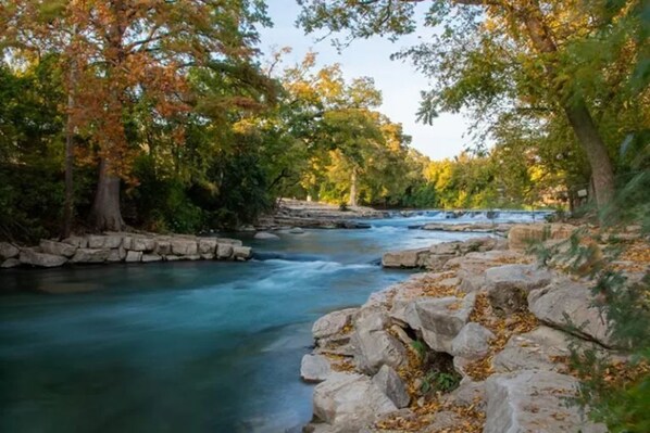 A river flowing through a rocky landscape with trees on either side.