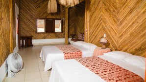 A room with two beds, a fan, and a window with wooden shutters. - Cabins in front of the Beach -  Playas - Ecuador (Playas)