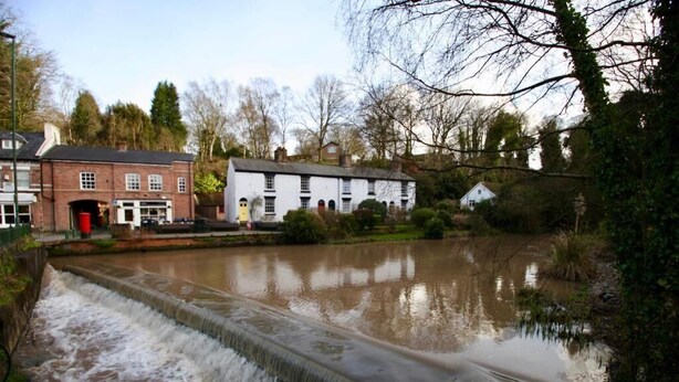A historic building with a water feature in front. - Lymm Cottage (Lymm)