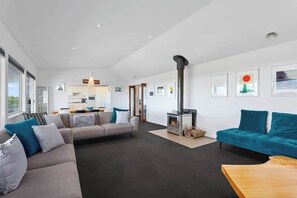 A modern living room with a sofa, a coffee table, and a fireplace.