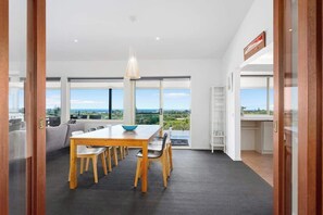 Un comedor moderno con una mesa grande, sillas y vistas al exterior.