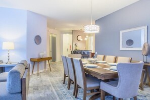Un espace repas comprenant une table en bois, des chaises et un luminaire suspendu.