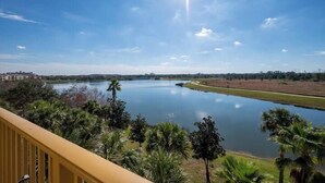 A river with a clear sky and palm trees in the foreground. - Vista Cay Lakeview Tropicana.  Walk to Epic Universe and the OCCC (Orlando)
