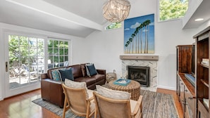 A spacious living room with a fireplace, a large window, and a ceiling light fixture. - Your escape to Napa Valley (Yountville)