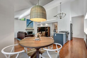 Enjoy meals around the central dining table, surrounded by comfortable seating and a fireplace.