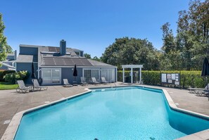 Relax by the pool surrounded by a paved deck and lounge chairs.