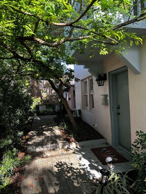 Pathway leads to a charming building with a door and window.