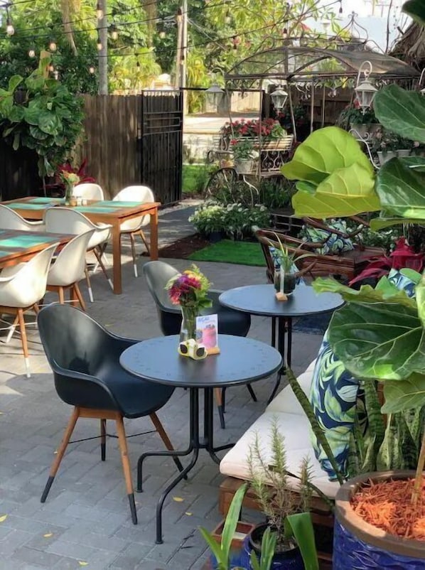 Relax in a serene outdoor space surrounded by lush greenery and potted plants, with comfortable seating options.