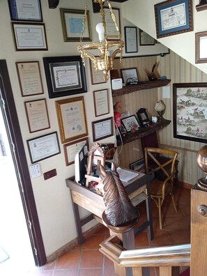 A room with a wooden desk, a horse sculpture, and multiple framed certificates on the wall. - Hotel La Mirada de Ronda  (Ronda)
