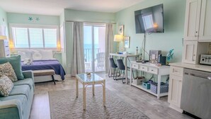 A room with a bed, a desk, a TV, and a view of the outdoors. - Palace 701 (Myrtle Beach)