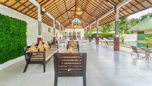 A covered outdoor seating area with a high ceiling and a central chandelier. - Kesari Penida by Mahaprana Home (Penida Island)