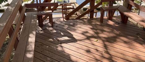 A wooden deck with benches overlooking a lake.