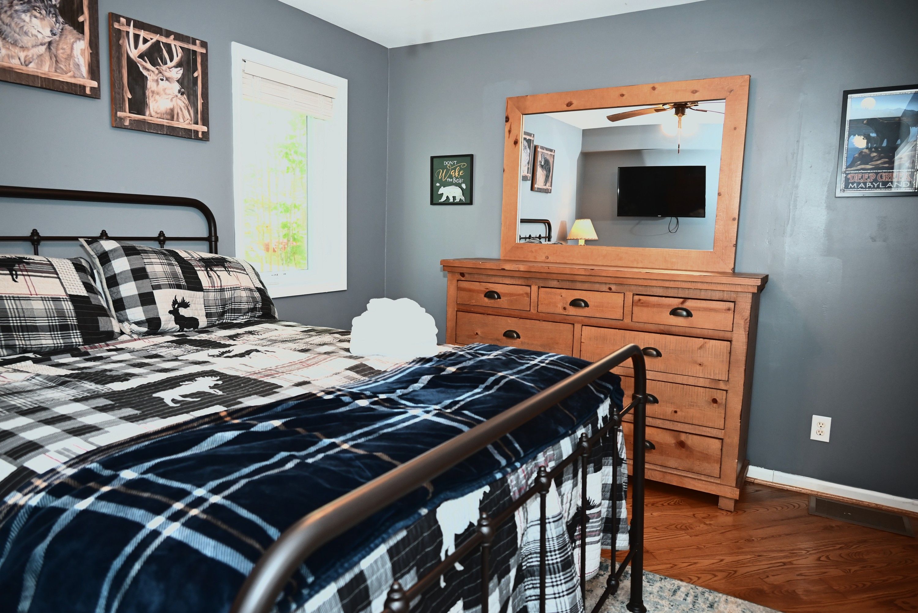 Een slaapkamer met een bed, een kaptafel, een spiegel en wanddecoratie.
