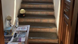 A staircase leading to a balcony with a view of a traditional tiled roof and a satellite dish. - Porta Conca (Rieti)