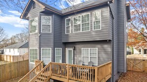 A two-story house with a wooden deck and a staircase leading to the front door. - NEW - High End Luxury Home in the Heart of Atlanta (Atlanta)